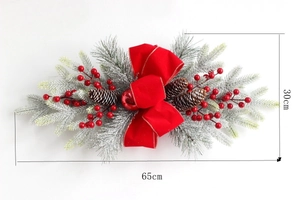 Détail de guirlande d'escalier avec noeud en velours rouge, baies, pommes de pin et neige