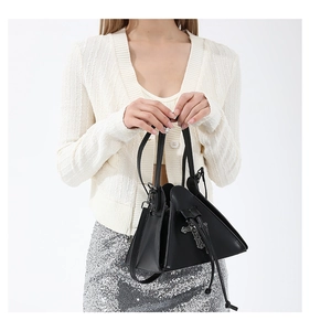Detail shot of a punk style black triangle crossbody bag with metal cross decor