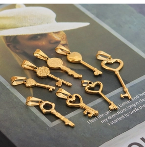 Detailed view of eight vintage gold heart-shaped key pendants on an artistic magazine page