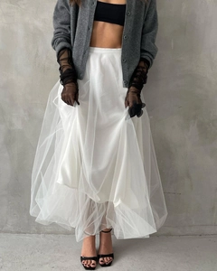 Detail shot of multi-layered white tulle skirt paired with a grey knit cardigan