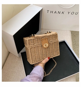 Detail der hellbraunen geflochtenen Box-Tasche mit goldenem Drehverschluss und Kettenriemen