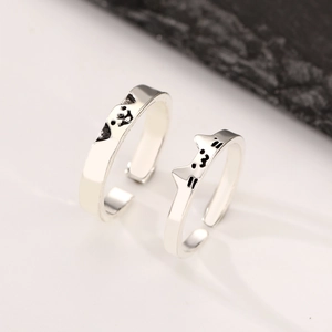 Detail view of adjustable silver cat and dog ear rings with black enamel details