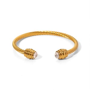Classic gold twisted cable bangle with zircon stones on a white background