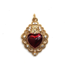 Detailed view of heart-shaped red gemstone pendant with baroque style gold openwork
