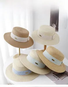 Flat top straw sun hats with textured ribbons and metallic labels in assorted colors