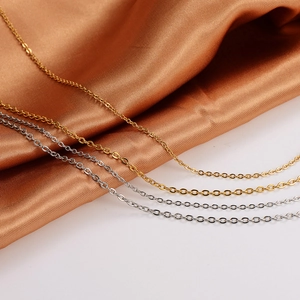 Minimalist 18K gold and silver stainless steel cable chains on elegant satin fabric