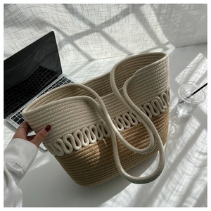 Detail of two-tone woven straw tote bag with wave texture and thick cotton rope handles