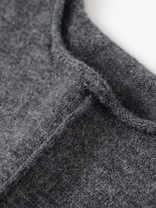 Detailed macro view of gray ribbed knit fabric texture and soft wool blend material