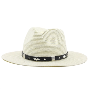 Détail du chapeau de paille crème avec bande en cuir noir et rivets métalliques argentés