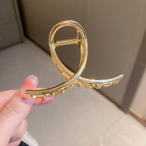 Detailed view of glossy gold alloy hair claw clip with strong metal spring mechanism