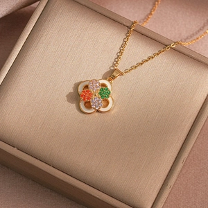 Macro shot of colorful clover pendant with sparkling zircon inlays on golden chain