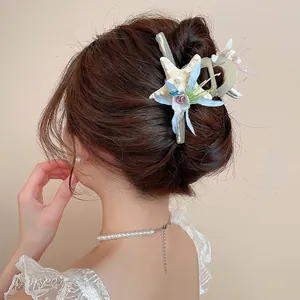 Pastel sea star floral hair clip with rhinestones worn on hair for beach vacation