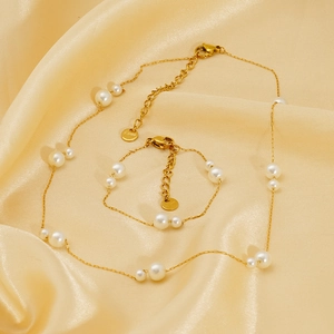 Détail du collier de perles en acier doré avec gravure S.Steel sur la plaque