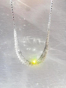 Macro shot of silver multi-row rhinestone fringe necklace with sparkling starburst light