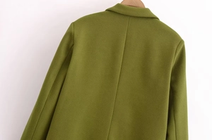 Dettaglio posteriore del cappotto di lana verde con cucitura centrale e trama di pregio