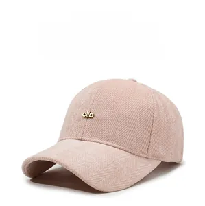 Detailed texture of pink herringbone baseball cap with gold ollo metal logo