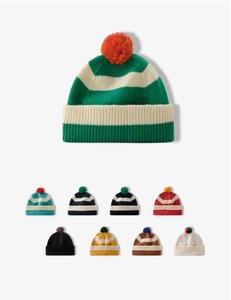 Detail view of colorful striped knit beanies with pom-poms in various color combinations