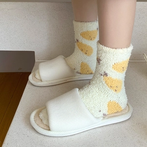 Gros plan de chaussettes en molleton corail et pantoufles blanches pour le confort maison
