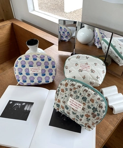 Detailed view of three quilted floral cosmetic bags on a desk with a warm home vibe
