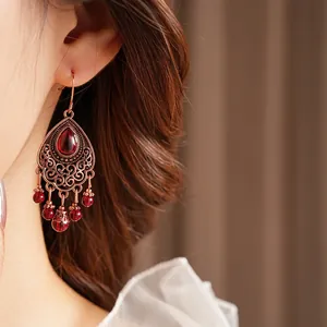 Vintage bronze drop earrings with hollow engraving and elegant red teardrop stones
