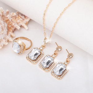 Elegant gold jewelry set with green gemstones including necklace, ring and earrings