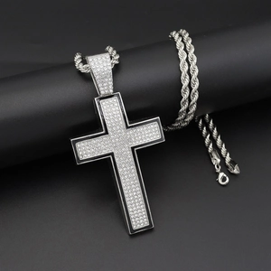 Detail shot of silver hip-hop cross pendant with clear rhinestones on black stand