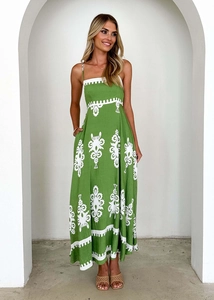 Close-up of white floral embroidery on a green linen summer maxi dress for women