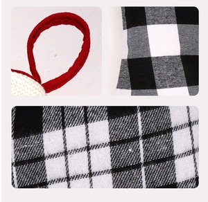 Detail of red-white woven lanyard and black-white buffalo plaid fabric on Christmas stocking