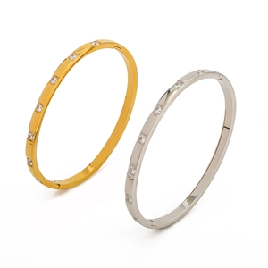 Close-up of gold and silver hinged bangles with round zircons in a modern design
