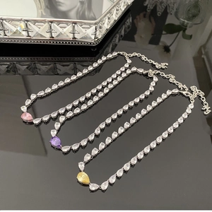 Vue détaillée de colliers argentés avec des pendentifs en cristal coloré en forme de poire
