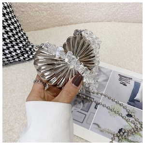 Detail of silver heart-shaped metal mini bag with crystal beads and chain strap