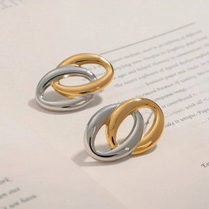 Boucles d'oreilles ovales entrelacées bicolores sur un fond de livre vintage