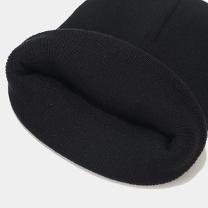 Close-up detail of the thick knitted texture and fold-over cuff on this black beanie hat