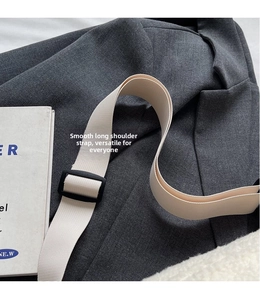 Detail of adjustable cream woven nylon shoulder strap with a matte black plastic buckle