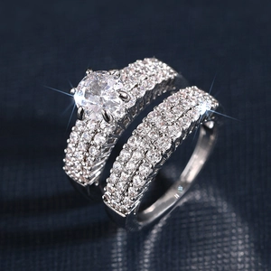 Macro shot of silver wedding rings set with cubic zirconia stones on blue background