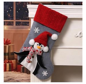 Detail of gray Christmas stocking with a 3D penguin wearing a red hat and scarf