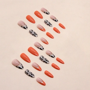 Long almond press-on nails featuring orange colors and leopard print with glitter