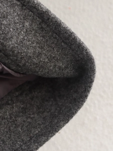 Nahaufnahme von dunkelgrauem Tweed-Stoff mit dicker wollartiger Textur und Details