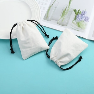 Two minimalist white cotton linen drawstring pouches for jewelry storage and gift packaging
