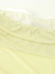 Macro view of light yellow mesh fabric with delicate white piping and layered texture
