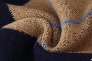 Macro shot of navy blue diamond pattern knit sweater showing texture and thick fabric