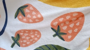 Close-up of soft flannel blanket featuring cute strawberry prints and yellow patterns