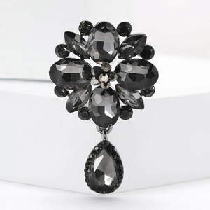 Detail of vintage flower brooch with dark grey crystals and black teardrop pendant