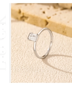 Détail d'une bague en argent avec moissanite taille émeraude sur socle en pierre