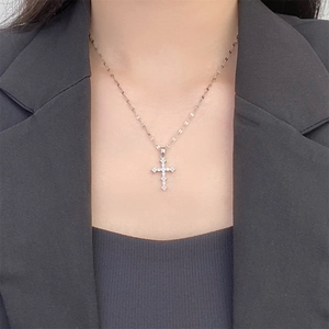 Classic silver plated cross necklace with sparkling zircon worn on a black blazer