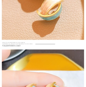 Detail of vintage French enamel clip-on earrings with orange and blue contrast colors