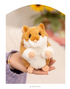 Close-up of a palm-sized brown and white plush hamster toy with soft fluffy texture
