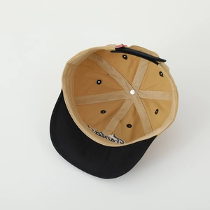 Détail des coutures internes à 6 panneaux et broderie de la casquette kaki et noire