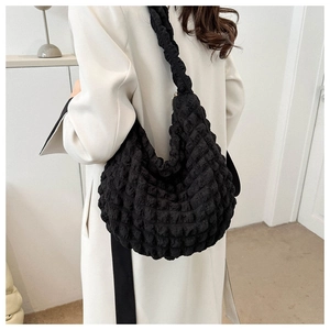 Close-up of black seersucker shoulder bag with puffer texture and large capacity design