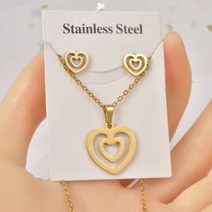 Detailed view of golden heart-shaped stainless steel necklace and earrings jewelry set